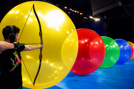 Μια σειρά από 15 γιγάντια μπαλόνια ενάντια σε ένα βέλος που τρέχει με ταχύτητα.